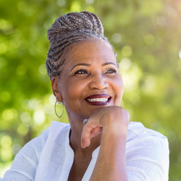 senior woman with hand under chin and smiling