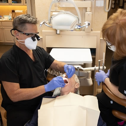 Dr. Scaff inspecting an older patient's mouth