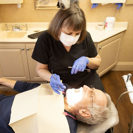 dental hygienist examining a patient's mouth