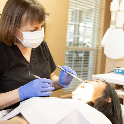 dental hygienist inspect a patient's mouth